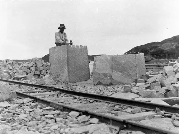 Stenhuggare kilar granitblock vid rälsen på Bohus-Malmön omkring 1910
