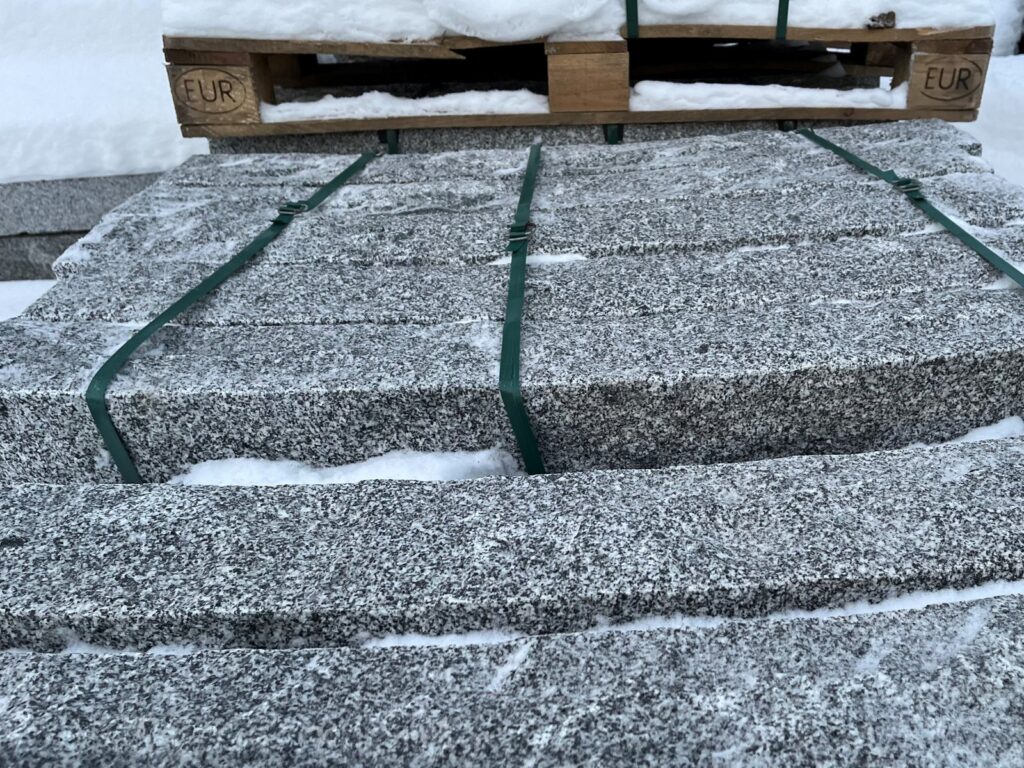 Kantsten i granit på pall i snö på vårt lager