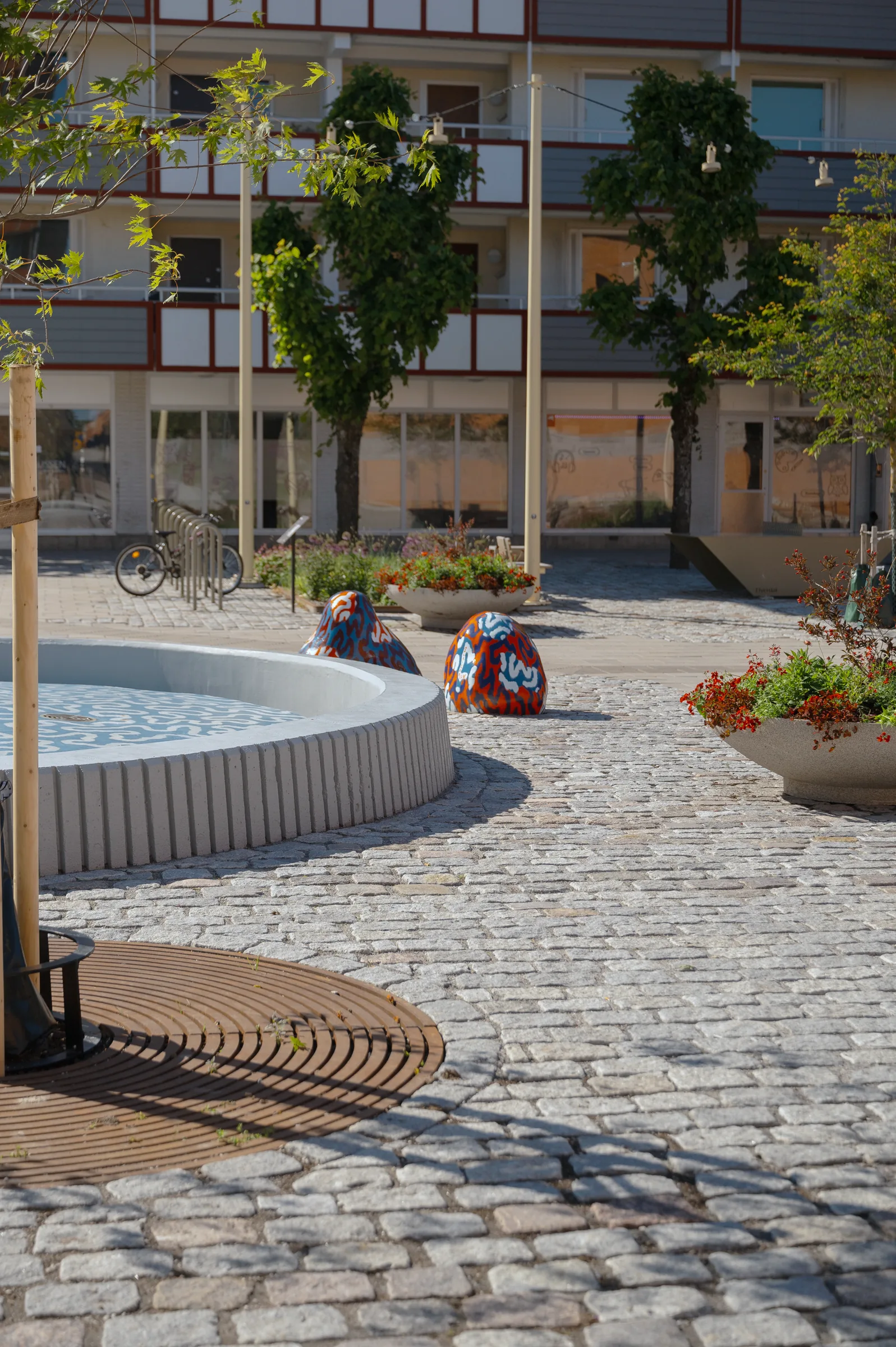 Återbrukad gatsten i granit runt fontänen på Skogås torg